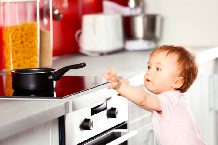 Bebe agarrando olla en la cocina